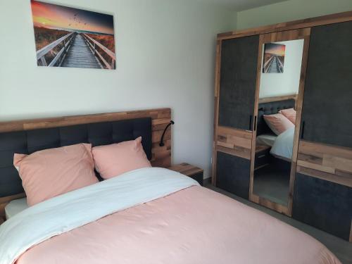 une chambre avec un lit et un miroir dans l'établissement Appartement neuf et climatisé, 4 personnes, à 150m de la plage, à Vias