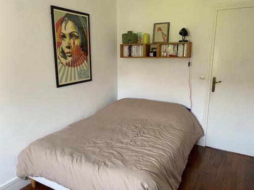 une chambre avec un lit et un tableau au mur dans l'établissement Appartement design, à Boulogne-Billancourt