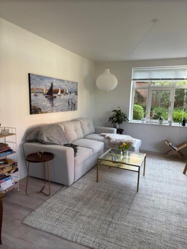 a living room with a couch and a table at Garden Apartment by the Sea in Sønderborg