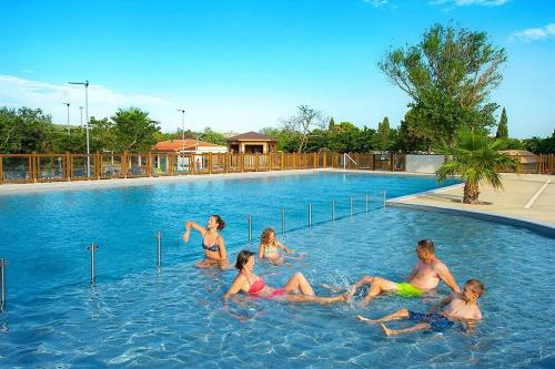 un groupe de personnes assises dans une piscine dans l'établissement Entre Mer et Roseaux - Piscine - Proche centre et mer - Petfriendly, à Port-la-Nouvelle