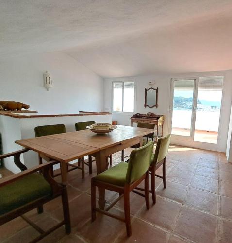 a dining room with a wooden table and green chairs at Casa Sinclair in Gaucín