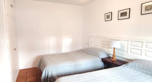 a bedroom with two beds and a lamp on a table at Casa Sinclair in Gaucín