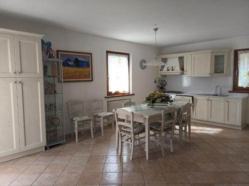 a kitchen with a table and chairs in a room at El Tabia De La Maria App Grün In Sospirolo in Sospirolo