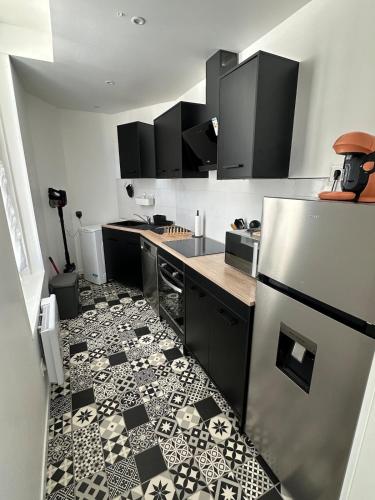 a kitchen with a black and white tile floor at Maison de Village in Châtillon-sur-Indre