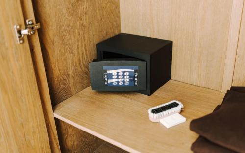 a small alarm clock on a wooden door with a comb at Septimia Hotels & Spa Resort in Odorheiu Secuiesc