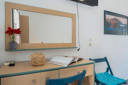 a desk with a mirror and a blue chair at Ilias Studios Sevasti Kalymnos in Panormos Kalymnos