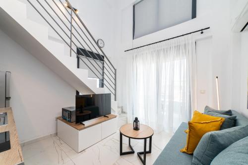 a living room with a blue couch and a tv at Nefeli & Nefeli Luxury Residential Complexes in Ofrínion