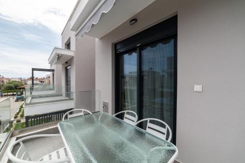 a balcony with a green table and chairs at Nefeli & Nefeli Luxury Residential Complexes in Ofrínion