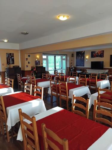 un restaurant avec des tables et des chaises rouges et blanches dans l'établissement le valoria, à Villegouin