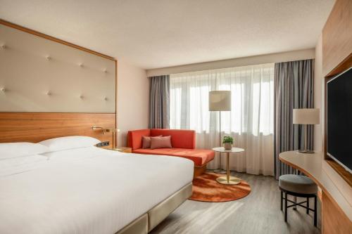 a hotel room with a bed and a red chair at Vienna Marriott Hotel in Vienna