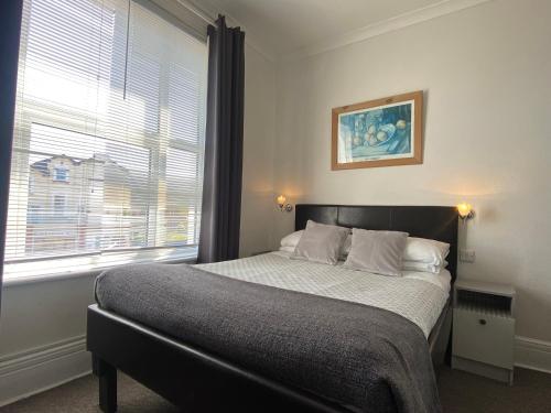 a bedroom with a bed with a large window at Marlborough Hotel in Shanklin