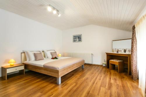 a bedroom with a large bed and a mirror at Apartmani Cvelic in Malinska
