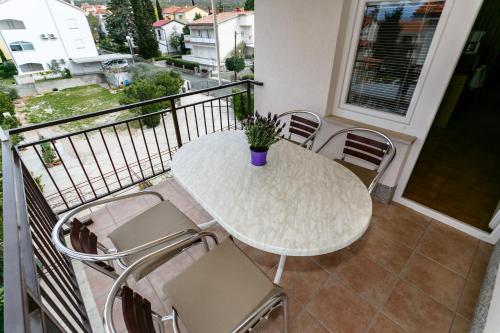 a white table and chairs on a balcony at Apartmani Cvelic in Malinska