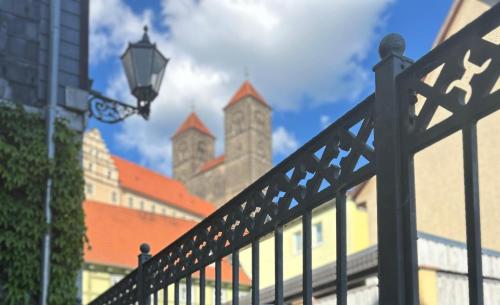 a black fence with a street light and buildings at Hotel Domschatz in Quedlinburg