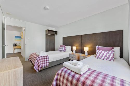 a hotel room with two beds and a table at Stylish 2-Bedroom Apartment in the Heart of Perth in Perth