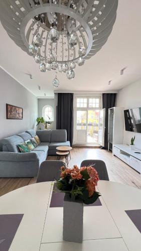 a living room with a couch and a chandelier at Diamond Apartment in Grudziądz