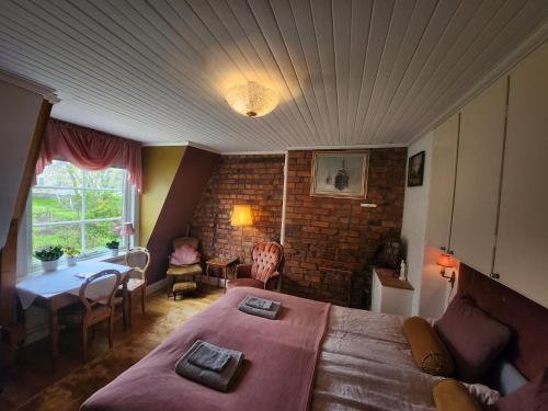 a bedroom with a large bed and a table and chairs at B&B Lilla Lotten in Östersund