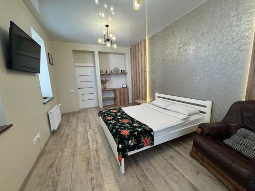 a small bedroom with a bed and a couch at Дуже файна квартира в самому центрі!!!!Переконайся!! in Rivne