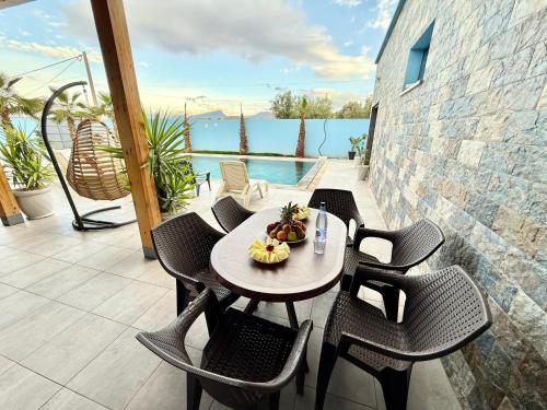 a table and chairs with a bowl of fruit on a balcony at Villa Berkane avec Piscine Jacuzzi privée Sans vis-à-vis in Berkawe