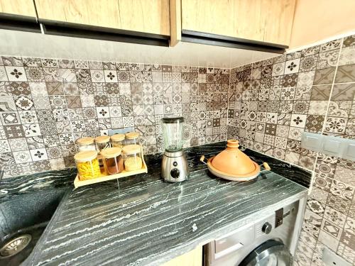 a kitchen counter with a blender on a counter top at Villa Berkane avec Piscine Jacuzzi privée Sans vis-à-vis in Berkawe