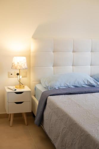 a bedroom with a bed and a lamp on a night stand at Eukalyptos 3BD apartment with yard in Chersonisos in Hersonissos