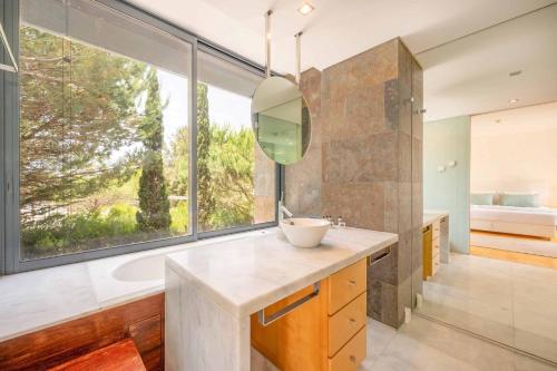 a bathroom with a tub and a sink and a mirror at GuestReady - Ocean Village in Troia