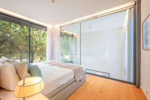 a bedroom with a bed and a large window at GuestReady - Ocean Village in Troia