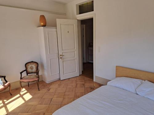 a bedroom with a bed and a chair and a table at VILLA Turmmattli in Sarnen
