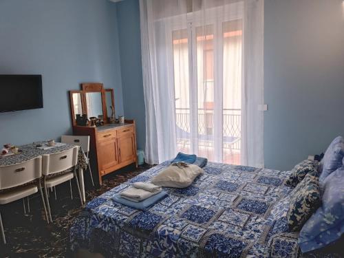 Un dormitorio con una cama y una cómoda y una ventana. en La Fenice Suite Room, en Finale Ligure