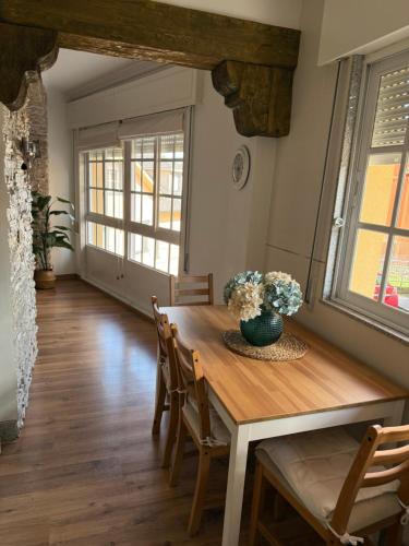 a dining room with a wooden table and chairs at Piso Praia da Rocha in Serres