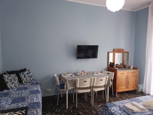 Un dormitorio con una mesa y sillas y una cama y un espejo. en La Fenice Suite Room, en Finale Ligure