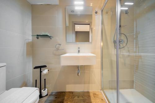 a bathroom with a sink and a shower at CARO Boutique Guest House in San Ġwann