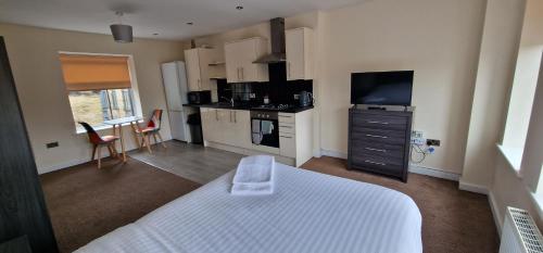 a bedroom with a white bed and a kitchen at PENTHOUSE SELF CHECK in APARTMENT IN CENTRAL HALIFAX in Halifax