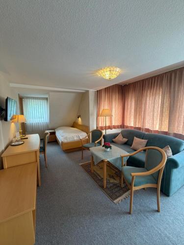 a hotel room with a couch and a bed at Hotel Berliner Hof in Braunlage