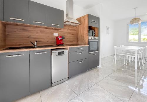 une cuisine avec des appareils en acier inoxydable et une table dans l'établissement Maison Avec Grand Jardin, à Buissou