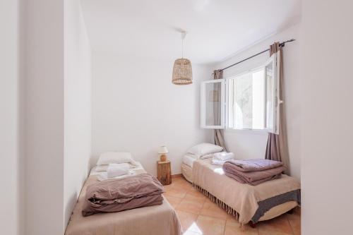 ein Schlafzimmer mit zwei Betten und einem Fenster in der Unterkunft L'Alivi di Losari 7 - piscine naturelle et jacuzzi in Belgodère