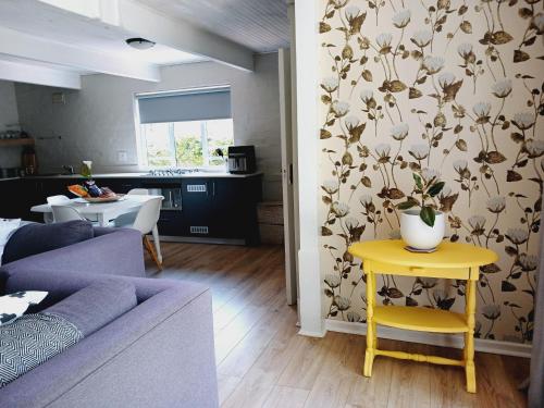 a living room with a purple couch and a yellow table at The Annex on 9th in Port Elizabeth