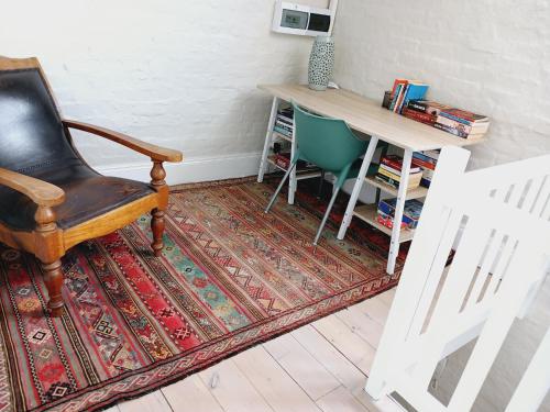 a room with a desk and a chair and a rug at The Annex on 9th in Port Elizabeth