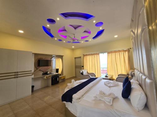 a bedroom with a large bed with a blue chandelier at Ricardo Beach Resort in Mandarmoni