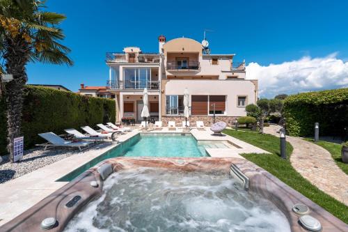 a house with a swimming pool in front of a house at Evan by Briskva in Poreč