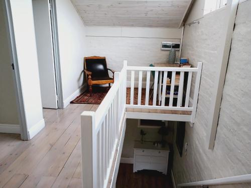 a white staircase in a room with a chair at The Annex on 9th in Port Elizabeth