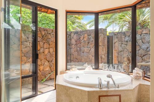 a bathroom with a bath tub and a window at Villa Arcana - Exclusive stay in Mauritius by Sealodge in Tamarin