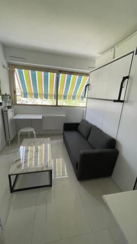 un salon avec un canapé et une table basse dans l'établissement Studio Cannes Marina, à Mandelieu-la-Napoule