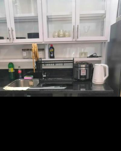 a kitchen counter with a sink and a microwave at Modern Bahay Kubo in Calaca