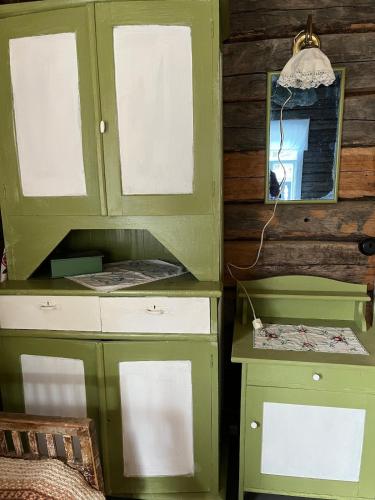 a green hutch with a mirror and a desk at Vintage atmospheric log house in Kivijärvi