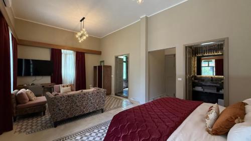 a bedroom with a large bed and a living room at Hotel Lost Ashrafieh in Beirut