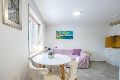 a white room with a table and a bed at Apartments and Rooms LEA in Bol