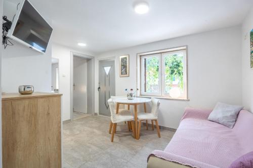 a bedroom with a table and a bed and a kitchen at Apartments and Rooms LEA in Bol