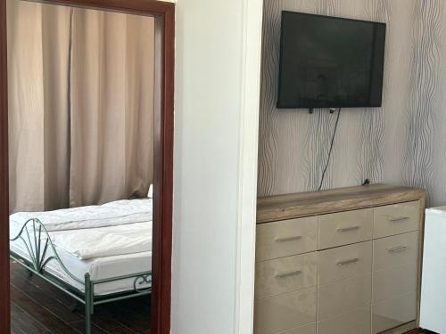 a bedroom with a dresser with a tv on the wall at ElStefanino House in Eforie Nord
