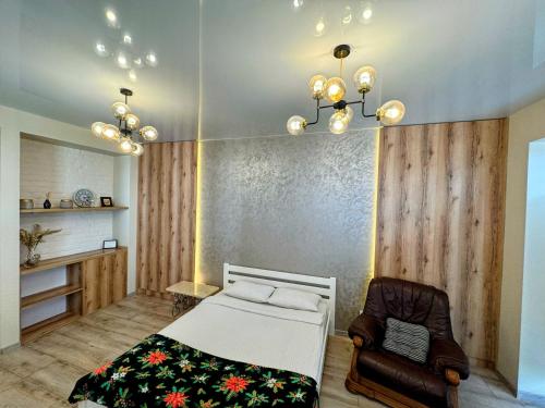 a bedroom with a bed and a chair at VIP apartment у центрі міста, новобудЖК Театральний,дуже простора in Rivne